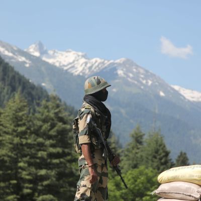 En soldat vid en vägspärr. I Bakgrunden syns väldiga snötäckta berg