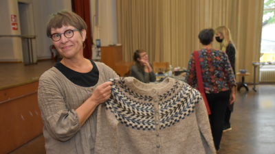 Nina Nurminen håller upp en tröja hon stickat.
