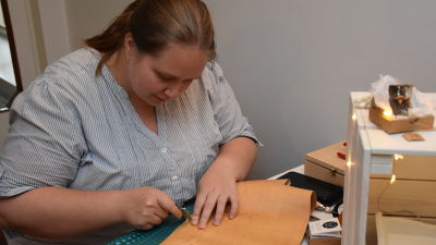 Minna Mollgren lutar sig över en bit ljusbrun näver.
