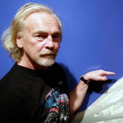 Lauri Nykopp osoittaa huiputtamatonta vuorenhuippua Grönlannin jäätiköllä. Teos on nimeltään Unclimbed #1.