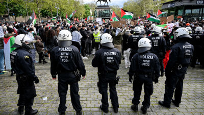 Polis följer med människor som samlats för Day of the Naqba