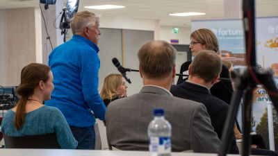 Bengt Gustavsson ställer en fråga på informationstillfället i Lovisavikens skola. På bilden syns Bengt som stpr upp bland publiken och en person som håller en mick framför honom.