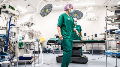 Sjukskötarna Carita Vuorenpää och Lotta Lantto arbetar i en operationssal på Jorvs sjukhus i Esbo, klädda i gröna sjukhuskläder och munskydd.