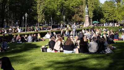 Ihmisiä nauttimassa aurinkoisesta päivästä puistossa.
