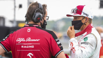 Kimi Räikkönen talar med teampersonal.