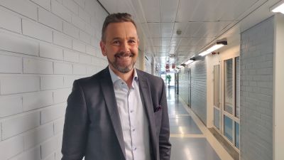 Man står i korridor och ler brett.