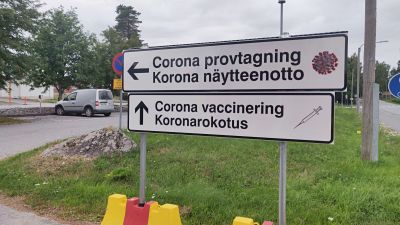 Skyltar som det står corona provtagning och corona vaccinering på.