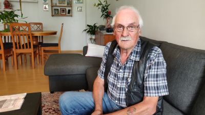 Man sitter på soffa.