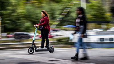 en suddig bild på en tjej som åker elsparkcykel