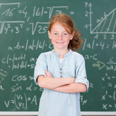 Flicka framför griffeltavla med matematiska uträkningar
