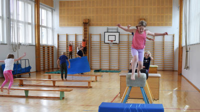Barn som hoppar i gymnastiksal.