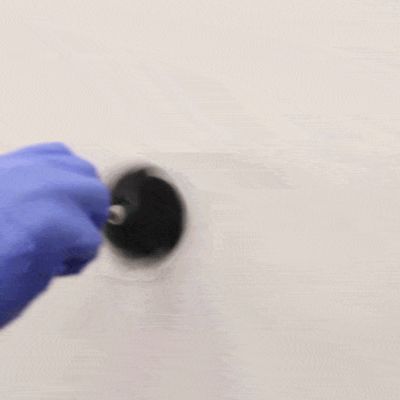 Kumihanskainen käsi pyörittelee sutia seinällä jossa on sormenjälkiä.