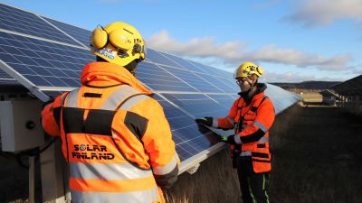 Aurinkopaneelien asennusta pellolla