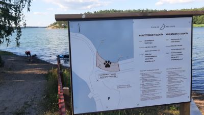 En skylt med en karta över var hundar får simma på hundstrand Tassnäs.