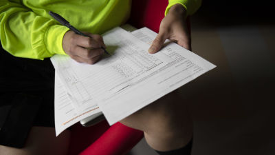 En person som man inte kan se ansiktet på fyller i blankett för inkomstrelaterad dagpenning.