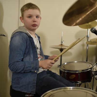 liten pojke spelar trummor