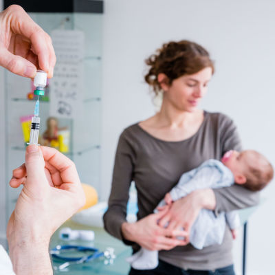 En läkare förbereder vaccinationsspruta för en baby.