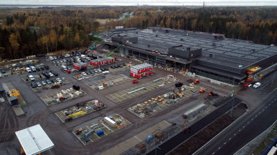 Affärscentret fotat från luften, stor parkeringsplats.