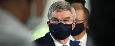 IOK:s ordförande Thomas Bach med munskydd, ser bekymrad ut