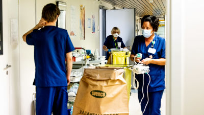 Vårdare som jobbar på coronaavdelning möts i sjukhuskorridoren.