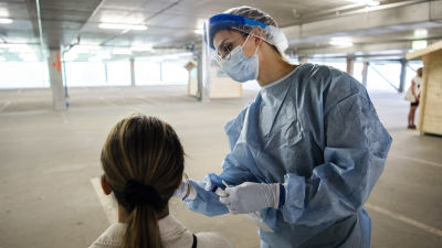 En sjukskötare tar ett coronatest på en kvinna.