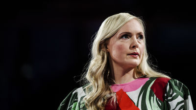 maria ohisalo i färgglad klänning, bakgrunden är svart