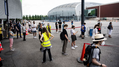 Människor står i kö till coronavaccinering vid Mässcentret i Helsingfors i juli 2021.
