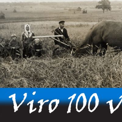 Vironen perhe viljankorjuussa. Vanhan ajan leikkuupuimuria vetää kaksi hevosta.