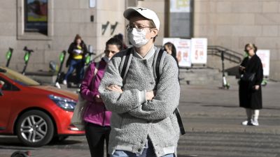 En person iförd munskydd i centrala Helsingfors.
