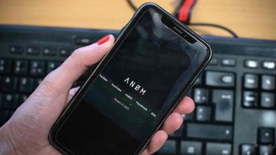 En närbild på en svart mobil med texten "ANOM".