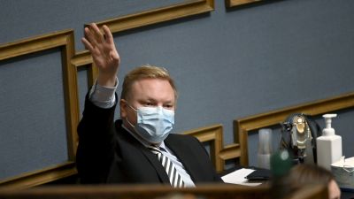 Antti Kurvinen gestikulerar i riksdagens pleniesal.