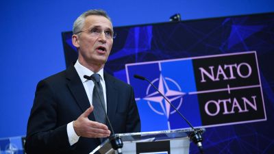 Natos generalsekreterare Jens Stoltenberg talar i mikrofon vid ett podium. Bakom honom syns Natos logo.