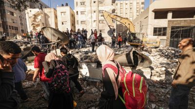 Palestinier på flykt från sina hem vandrade förbi husruiner i Gaza City på söndagen.