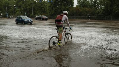Man som cyklar i en pöl i Helsingfors.