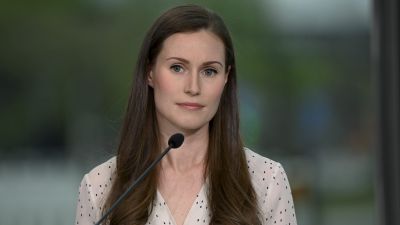 Sanna Marin i vitprickig skjorta.