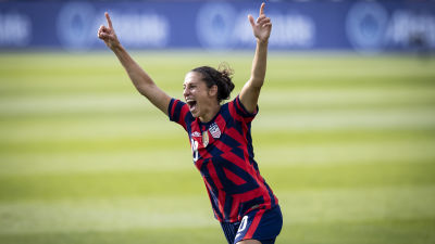 Carli Lloyd i rödblå tröja jublar med bägge händerna i luften.