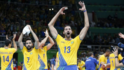 Två gulklädda brasilianska volleybollspelare jublar efter vinst.