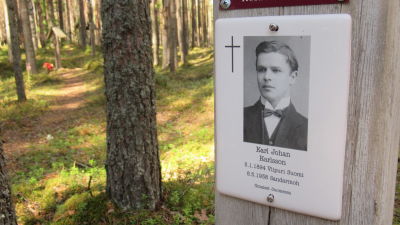 En minnesskylt. På skylten ett svartvitt foto av en ung finsk man.