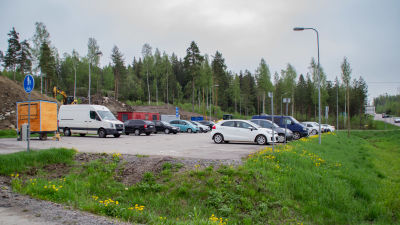 Bilar på en parkeringsplats intill en väg.