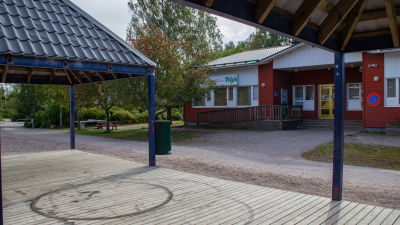 I förgrunden syns svarta cirklar gjorda med moped på en träterrass. I bakgrunden ett trähus med skylten Pleissi på väggen.