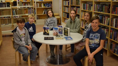 Dag Bahér, Casper Malmsten, Birna Hampf, Lovisa Lindbom, Alma Lindholm. Rudi Viljanen sitter vid ett bord i biblioteket i Degerby skola.
