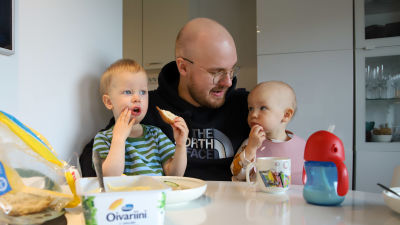 Tonreåbon Atte Tolonen sitter vid matbordet med sina söner och äter bröd.