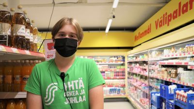 Kasper, sommarjobbare på Sale i Nagu, står i butiken iförd en grön t-skjorta.