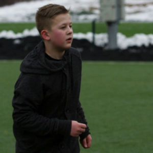 Poika pelaa jalkapalloa Helsingin Stadionilla