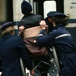 En rullstol lyfts in i ett snälltåg, 1985