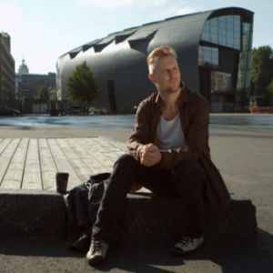 Mies istuu kansalaistorilla Helsingissä.