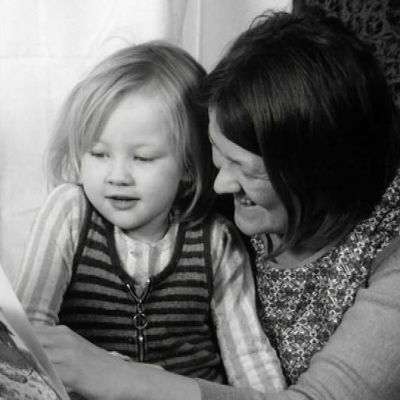 Äiti lukee kirjaa lapsensa kanssa