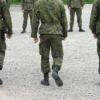 Varusmiehet marssivat kentällä.