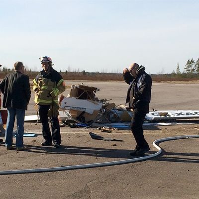 Pelastushenkilöstöä Nummelan lentokentällä pudonneen pienkoneen hylyn vierellä.