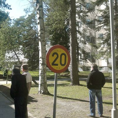 Paloauto ja ihmisiä pihalla.